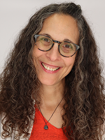 Image of Eve Abrams wearing a red shirt with long wavy brown hair and glasses